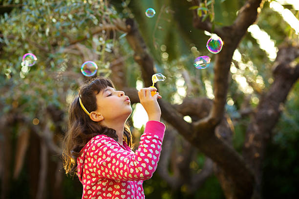 istock Young Girl Blowing Soap Bubbles 182765800