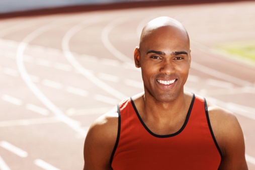 Portrait of a smiling handsome male athlete on running track