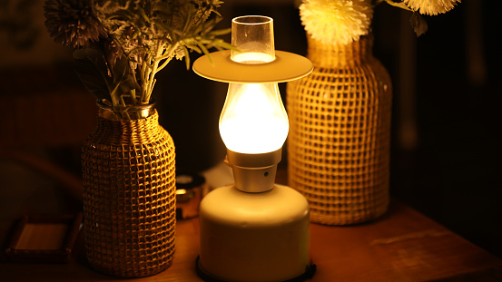Night view of lantern and dried flowers on wooden table