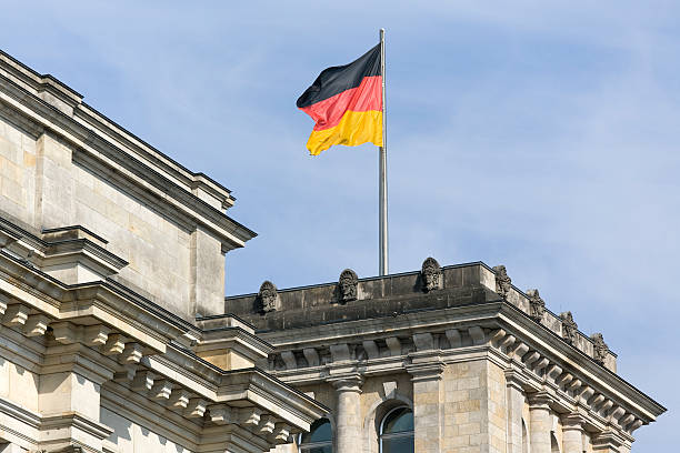 Reichstag with national flag and blue sky in Berlin, Germany