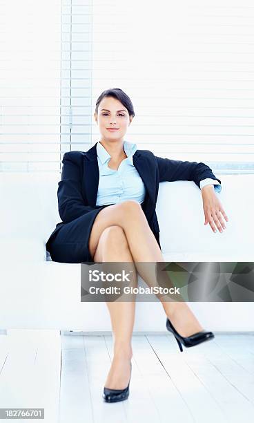 Empresaria Sonriente Sentado En Un Sofá En La Sala De Estar Foto de stock y más banco de imágenes de 30-34 años