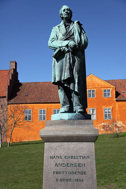 Hans Christian Andersen in his home town Odense "Sculpture of World Famous Danish fairy tale writer and poet Hans Christian Andersen (1805 - 1870) in front of the monastery of the Sankt Knuds kirke (church) in Odense, the town where he was born." hans christian andersen stock pictures, royalty-free photos & images