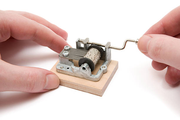 Playing a Small Music Box Male hands playing with a tiny music box. White background. White background. hurdy gurdy stock pictures, royalty-free photos & images