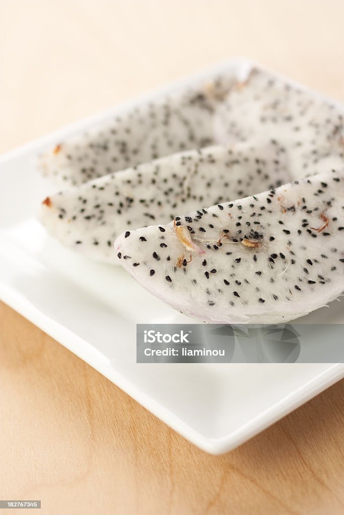 Dragon fruit slices on a plate Dragon fruit slices on a plate on wooden desk Beauty Stock Photo