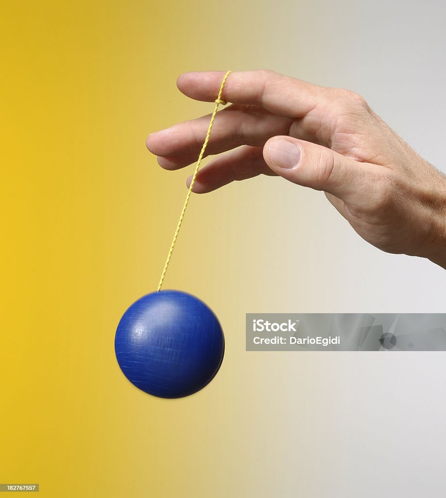 Masculino mão Jogando com um blu yo-yo sobre fundo amarelo - Royalty-free Ioió Foto de stock