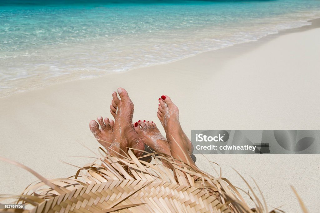 Coppia rilassante sulla battigia di una spiaggia tropicale - Foto stock royalty-free di Caraibi