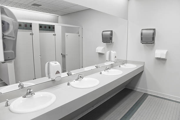 An empty commercial/public restroom A public restroom's sinks. public restroom stock pictures, royalty-free photos & images