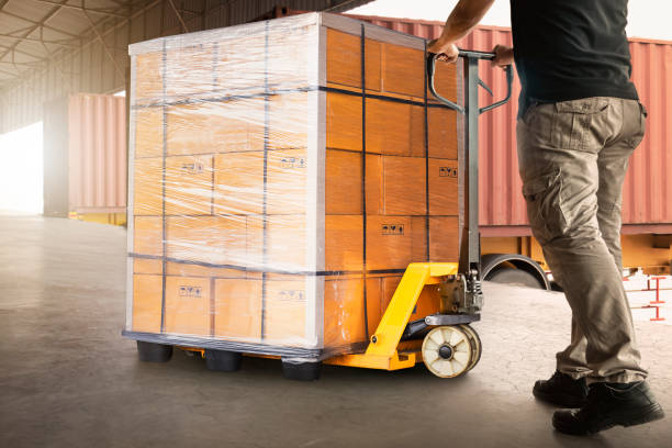 istock Workers Unloading Package Boxes on Pallet in Warehouse. Hand Pallet Truck Loader. Delivery Service. Supply Chain Shipment Goods. Distribution Supplies Warehouse Logistics 1827687315