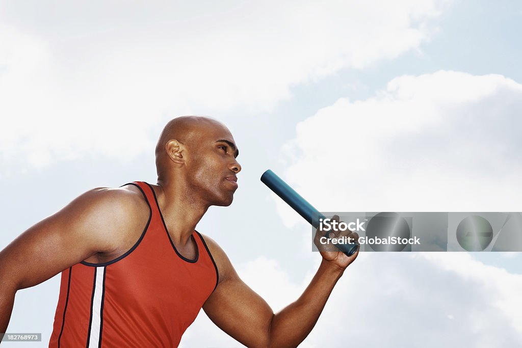 Athletic homme tenant baton et de course - Photo de Course de relais libre de droits