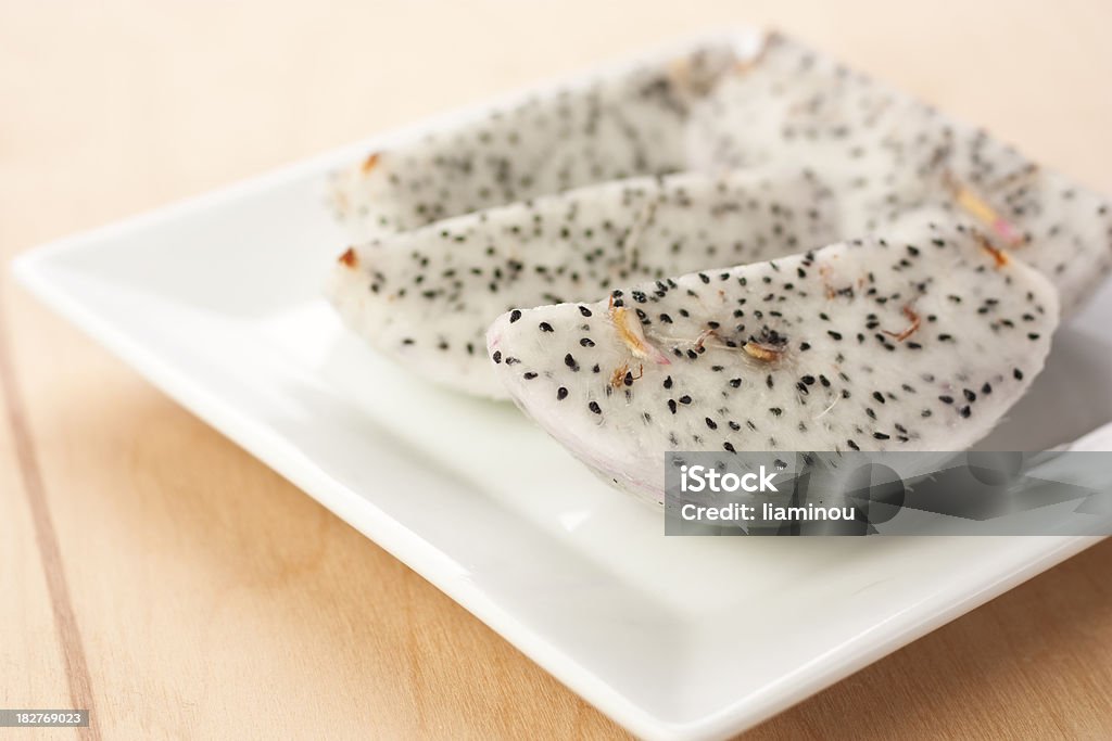 Dragon fruit slices on a plate Dragon fruit slices on a plate on wooden desk Beauty Stock Photo