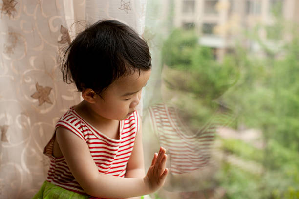 istock Cute little girl looking out the window 182769265