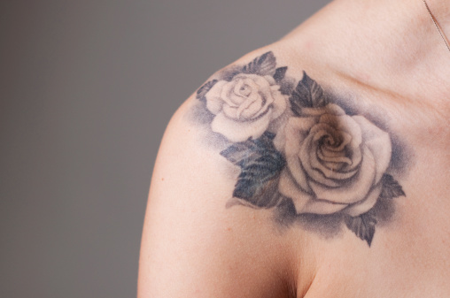 Close up of two rose tattoos on women's shoulder