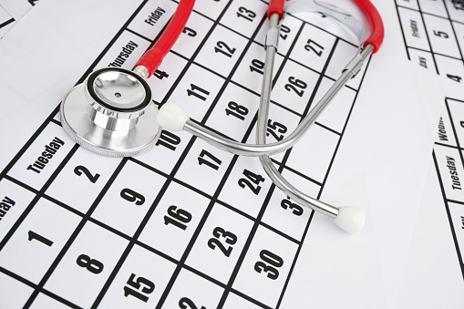 Medical examination concept, red stethoscope on calendar page.