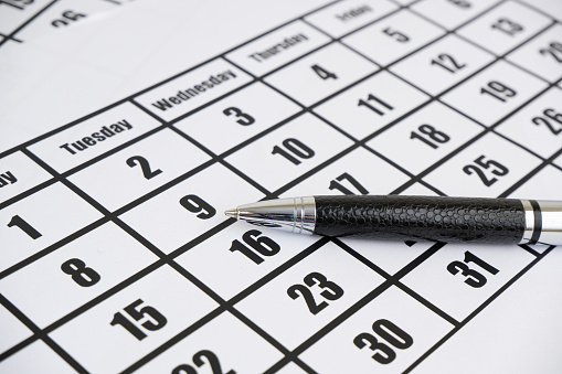 Calendar with metallic pen. Business time concept.