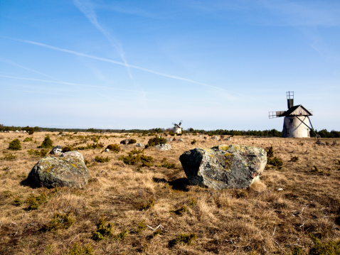 Rocks with two old windmills in the background a few miles south of Burgsvik at Gotland.