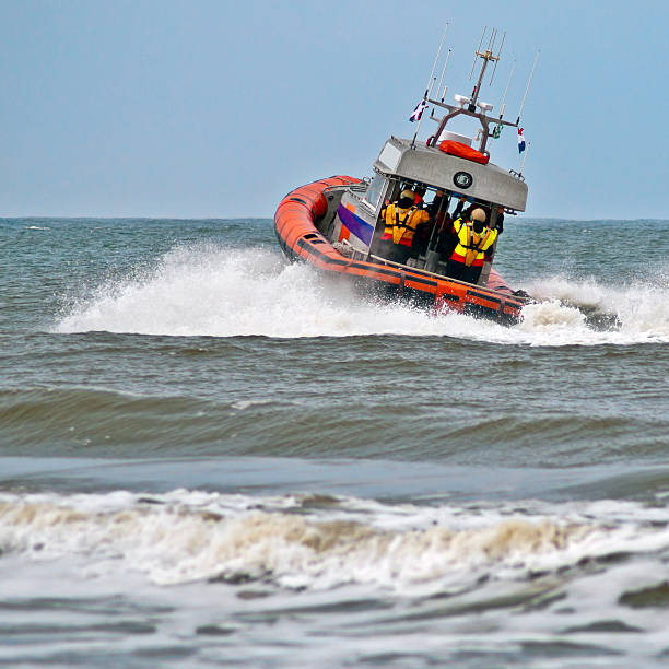 A lifeboat rides a wave as it sets off into action stock photo