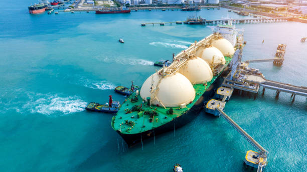 LNG (Liquefied natural gas) tanker anchored in Gas terminal gas tanks for storage. Oil Crude Gas Tanker Ship. LPG at Tanker Bay Petroleum Chemical or Methane freighter export import transportation buque cisterna de gnl (gas natural licuado) anclado en tanques de gas de terminal de gas para su almacenamiento. buque cisterna de gas crudo de petróleo. glp en tanker bay petroleum chemical o transporte de importación de carga de metano