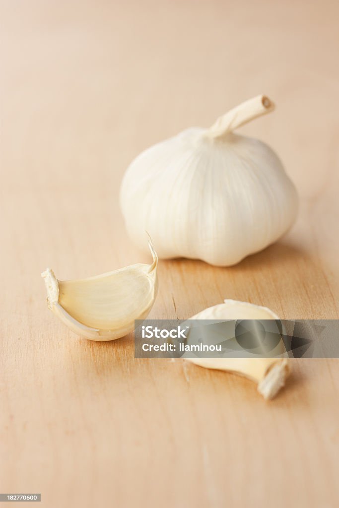 garlic head with two gloves garlic head with two gloves on wooden table Clove - Spice Stock Photo