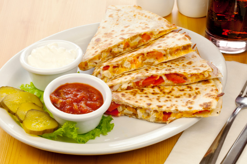 Chicken quesadillas with sour cream and salsa.