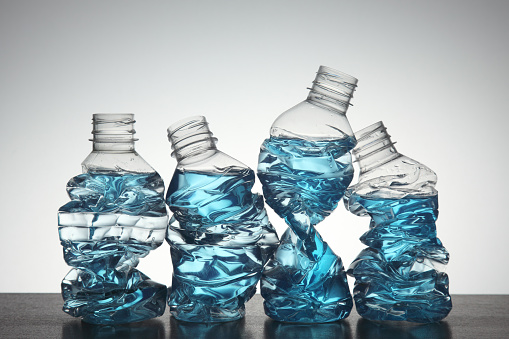 Four plastic bottles filled with blue liquid