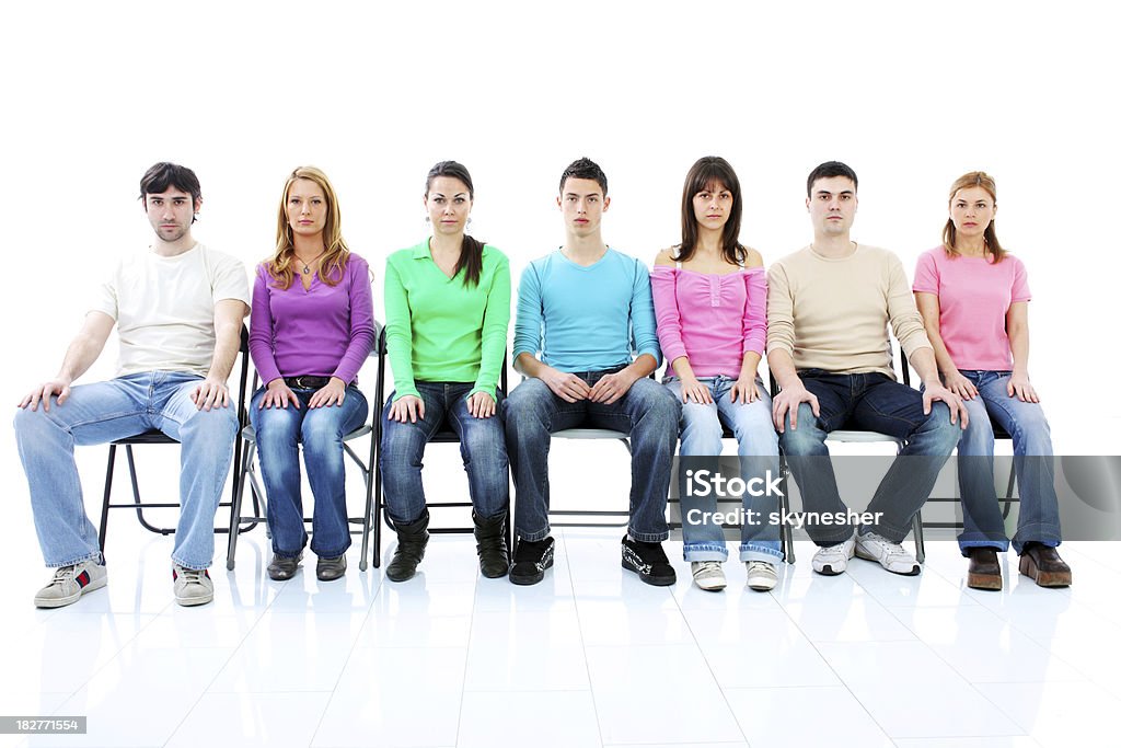 Gruppo di giovani persone seduto e guardando la telecamera. - Foto stock royalty-free di Adolescente