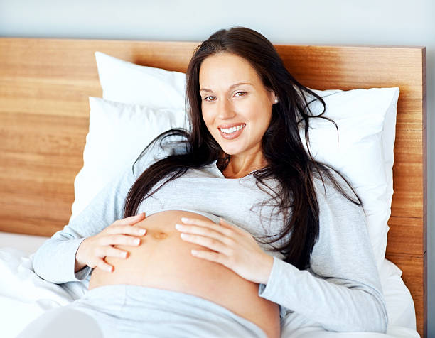 istock Happy pregnant young lady relaxing on bed 182771968
