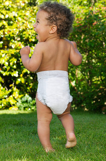 vista posteriore di un bambino a piedi e sorridente - baby1 foto e immagini stock