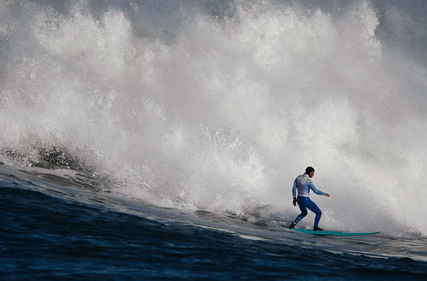 Surfing a Huge Wave Surfing a huge wave at the Mavericks break off Half Moon Bay California. Great action shot. mavericks california stock pictures, royalty-free photos & images