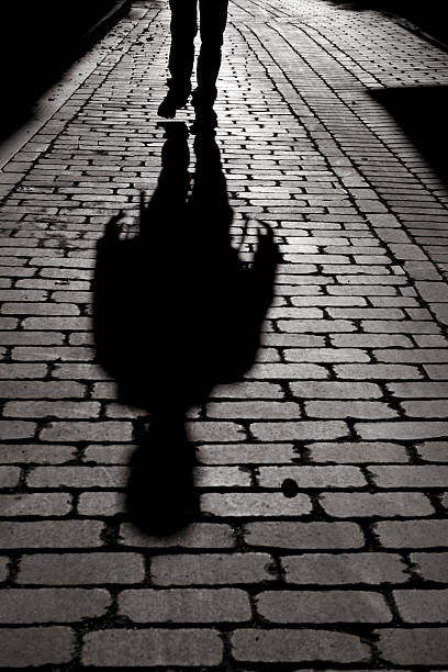 istock Black And White Shadow Of Man Walking On Sidewalk 182773084
