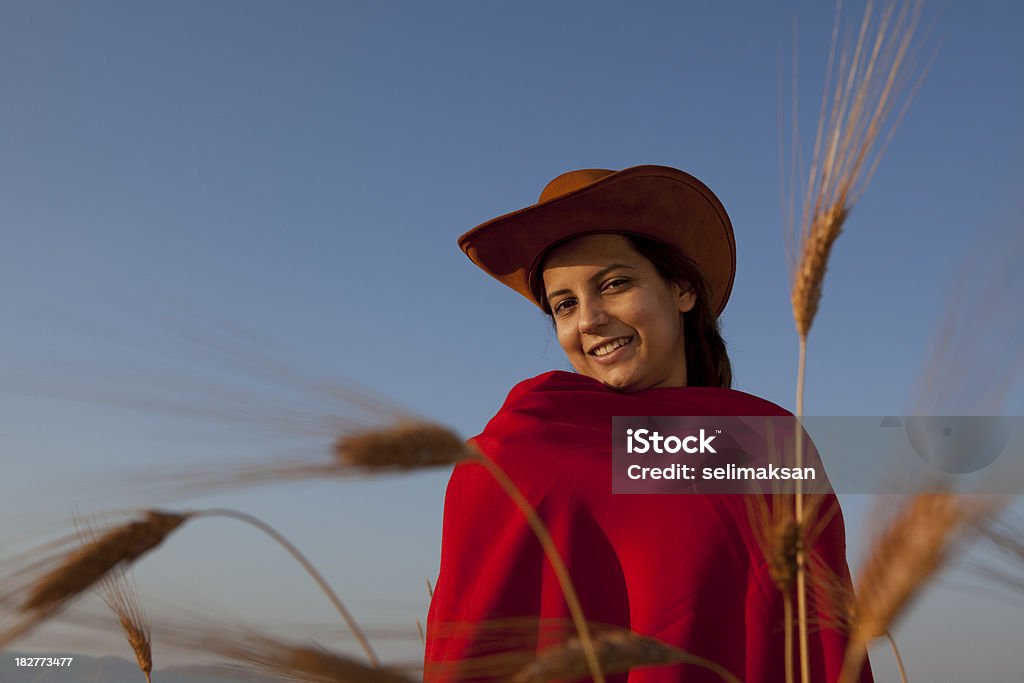 Милая женщина в поле пшеницы с красной pelerine - Стоковые фото Весёлый роялти-фри
