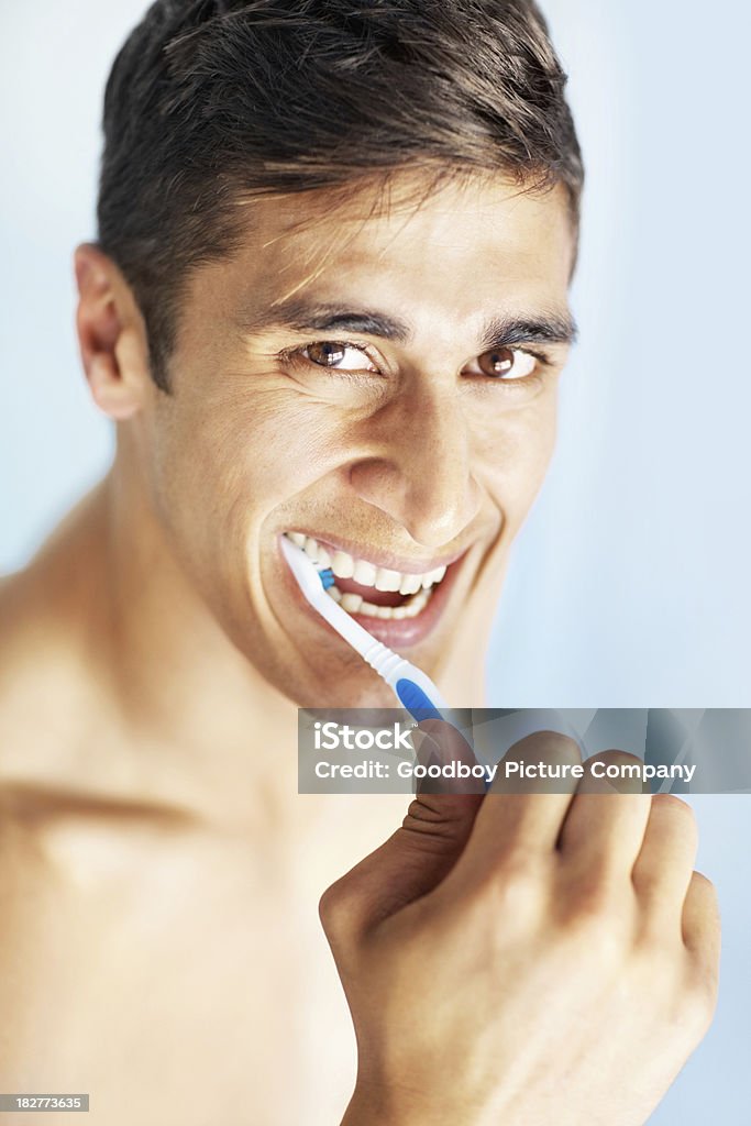 ポートレートの幸せな若いギィブラッシングで彼の歯 - お手洗いのロイヤリティフリーストックフォト