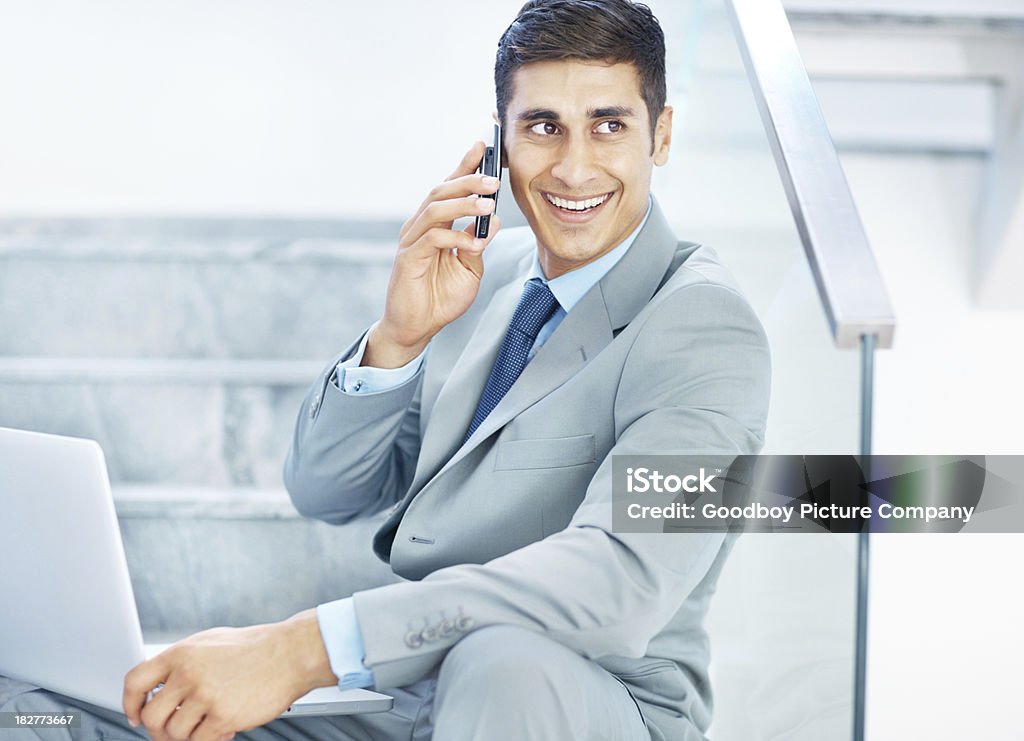 Szczęśliwy biznes człowiek mówi na komórkowy podczas schodach - Zbiór zdjęć royalty-free (20-29 lat)