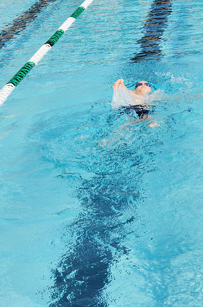 istock Young Boy Male Athlete Backstroke Swimming Racing in Pool 182773975