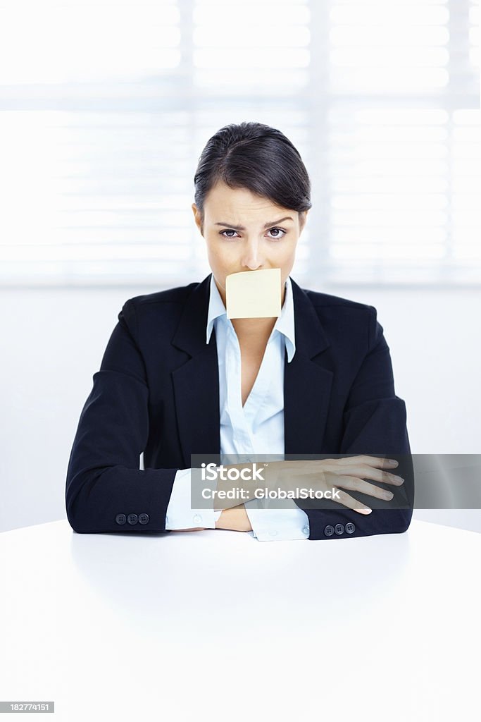 Business-Frau am Tisch mit Klebezettel auf dem Mund - Lizenzfrei Klebezettel Stock-Foto