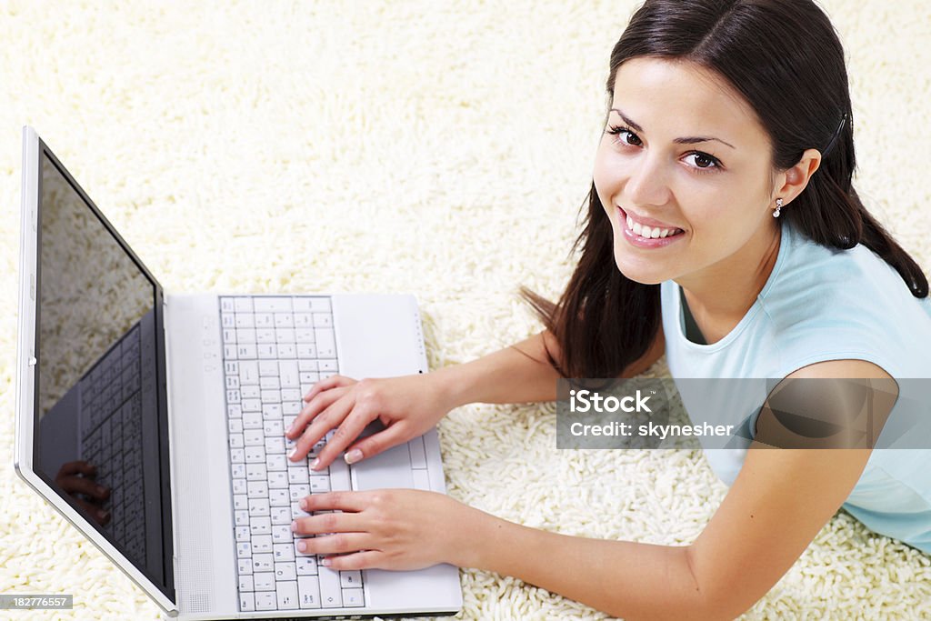 Belle jeune femme, souriant et à l'aide d'un ordinateur portable. - Photo de Adulte libre de droits