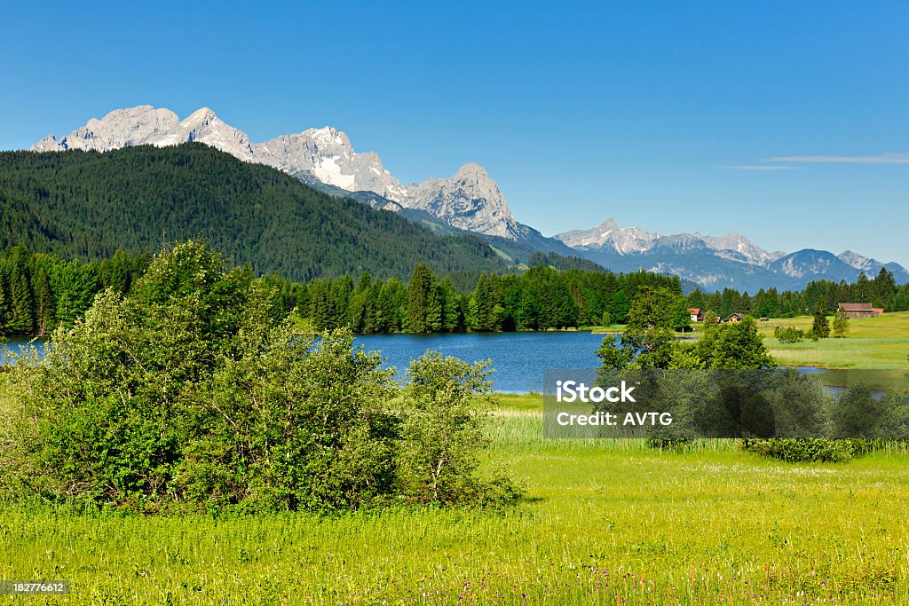 Bavaria Landscape with Barns and Lake against Mount Zugspitz Germany Stock Photo