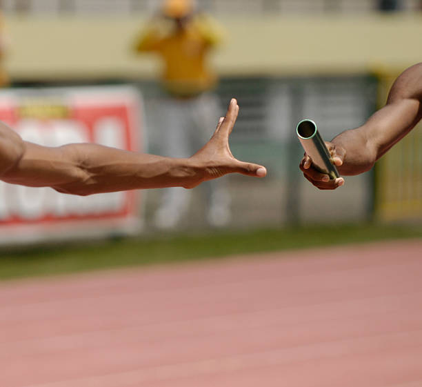istock A runner passing a baton to another person 182776651