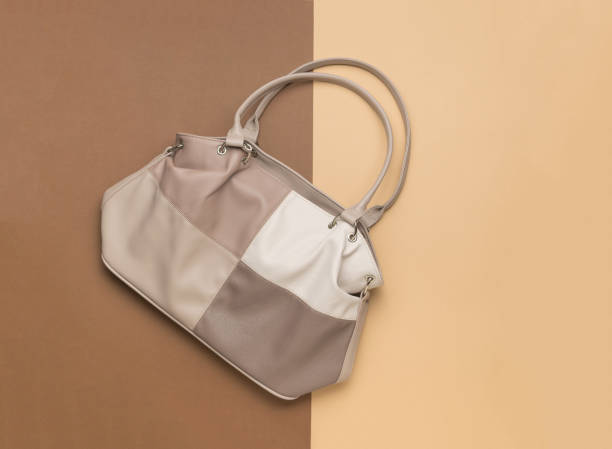 istock An original women's handbag on a two-tone background. 1827771948