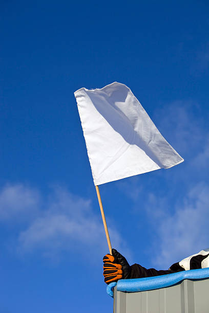 istock White Auto Race Flag against a Blue Sky 182777412
