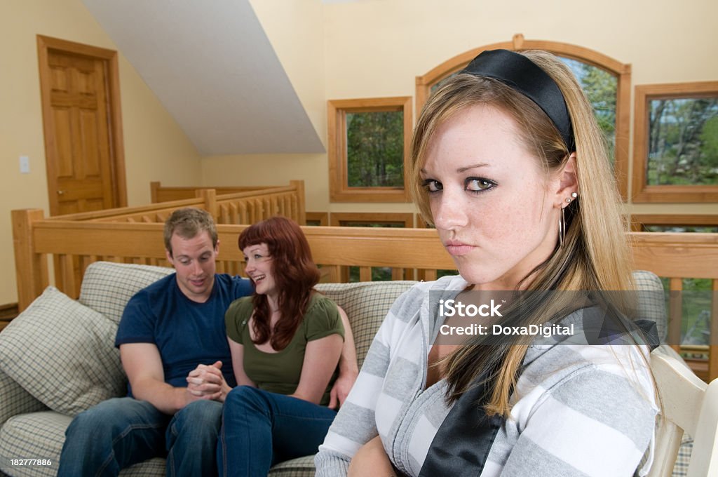 Jealous Young Woman Woman looking upset as couple is intimate in background. 20-24 Years Stock Photo