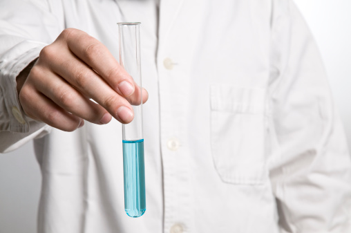 scientist holding a vial with blue liquid