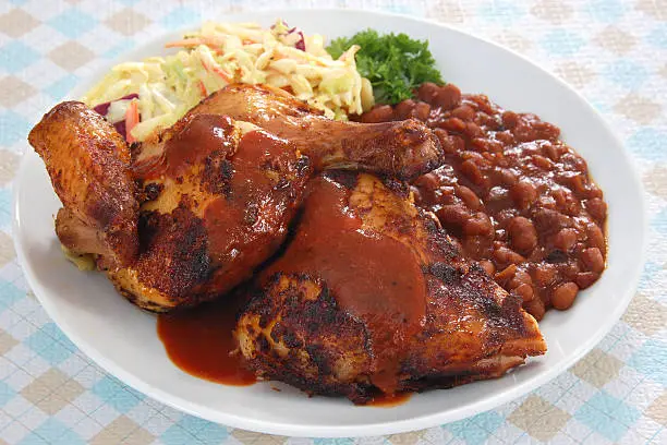 "Southern slow-cooked barbecue chicken served with barbecue sauce, cole slaw, and baked beans.More barbecue images:"