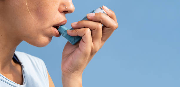Woman using asthma inhaler during asthma attack.