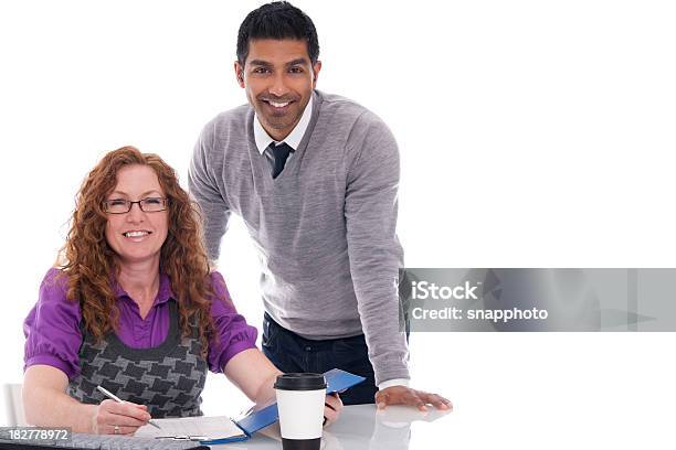 Man And Woman In An Office Stock Photo - Download Image Now - Meeting, Clipboard, Multiracial Group