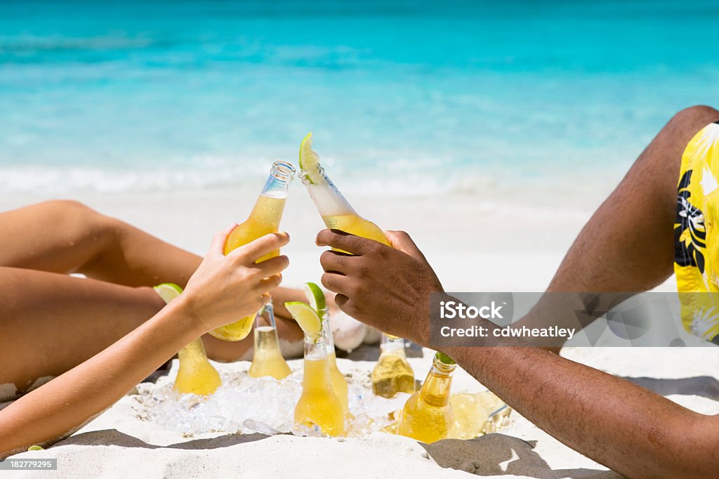 Par tomar el sol en la playa caribeña y haciendo un brindis - Foto de stock de Cerveza libre de derechos