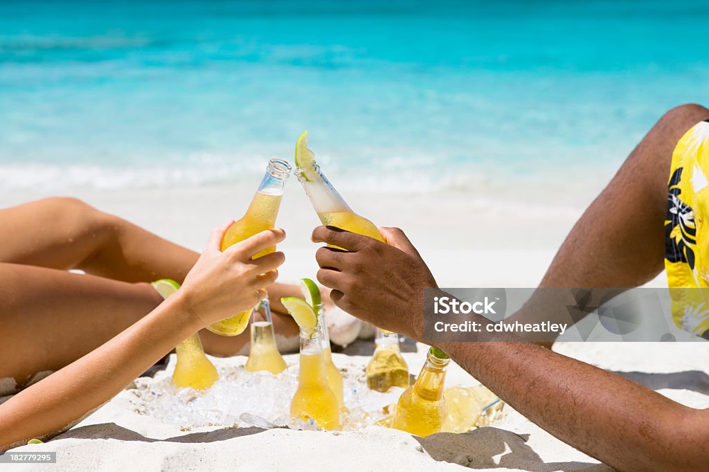 カップルのカリブ海でのビーチでの日光浴やでの乾杯 - ビールのロイヤリティフリーストックフォト
