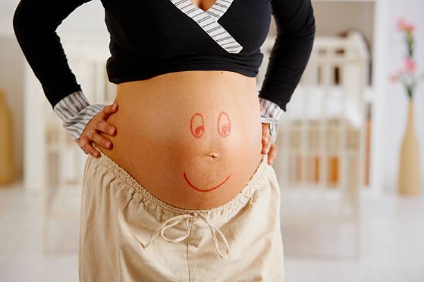 istock Pregnant belly with smiley face 182779854