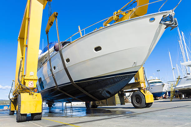seasonal mending large luxury motor yacht hanging from a shipyard craneCHECK OTHER SIMILAR IMAGES IN MY PORTFOLIO.... dry dock stock pictures, royalty-free photos & images