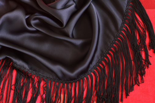 Close up of a black shawl in spanish style on red background.Related images: