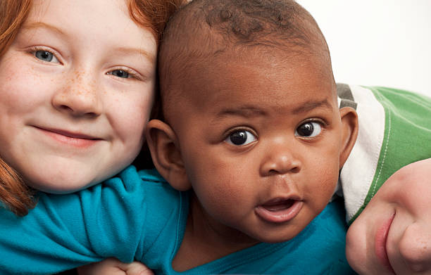 elementary age redhead girl hugging 6month old adopted black sister sisters and brother.Check out our other shots of children! 6 11 months stock pictures, royalty-free photos & images